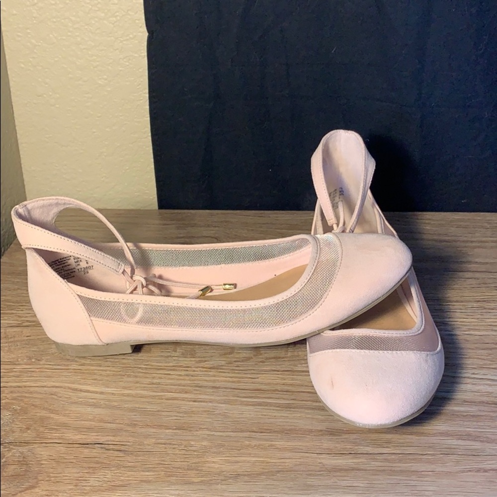 A pair of light pink flats with a ankle tie